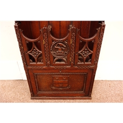  19th century oak gun cabinet, raised carved top with knights helmet finial, planked back with scrolled sides carved 'I Carved The Rack As You May See To Hold The Guns For Doctor Lee AD 1864 J. E. Humphries Thame'  three pierced carved doors aand fall front carved with crest 'Fide et Constantia' trans. Strong in Strength and Work W51cm, H187cm, D25cm  