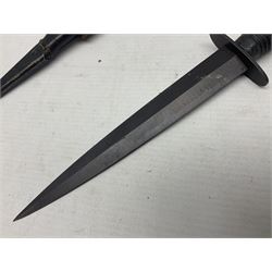 Third Pattern Commando Knife or Dagger with 17.5cm flattened diamond section blade and regulation black painted ribbed copper hilt with brass pommel nut; stamped William Rodgers Sheffield England to the cross-piece; in black painted brass mounted leather scabbard L34.5cm overall