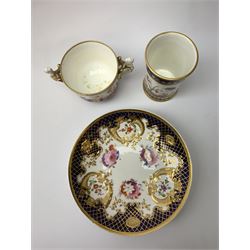 Early 19th century Spode chocolate cup and cover, with twin figural winged handles, decorated with a continuous band of flowers between dark blue gilt detailed borders, H8cm, together with a similarly decorated spill vase, H10.5cm, and a 19th century Ridgway dish, decorated with flowers and moulded cornucopia within a gilt hatched dark blue border, pattern number verso 2/852, D19cm