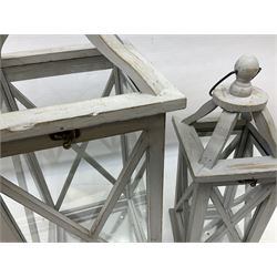 Two wooden lanterns with four glass sides, loop handles and open tops, largest example 58cm