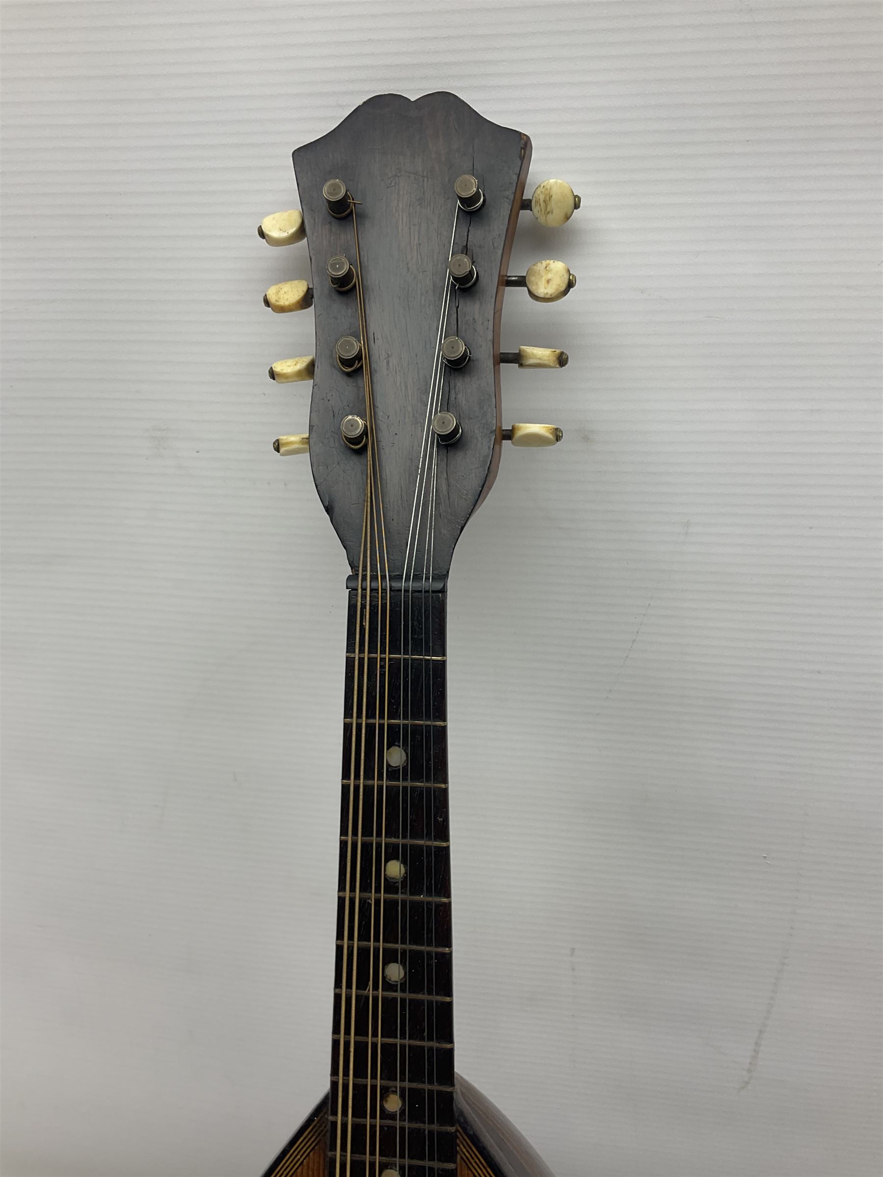 Late 19th century Italian lute back mandolin with segmented bowl back, bears label Gennaro Maglioni Napoli L61cm; in ebonised wooden case; together with another similar damaged Italian lute back mandolin for restoration or spares (2)