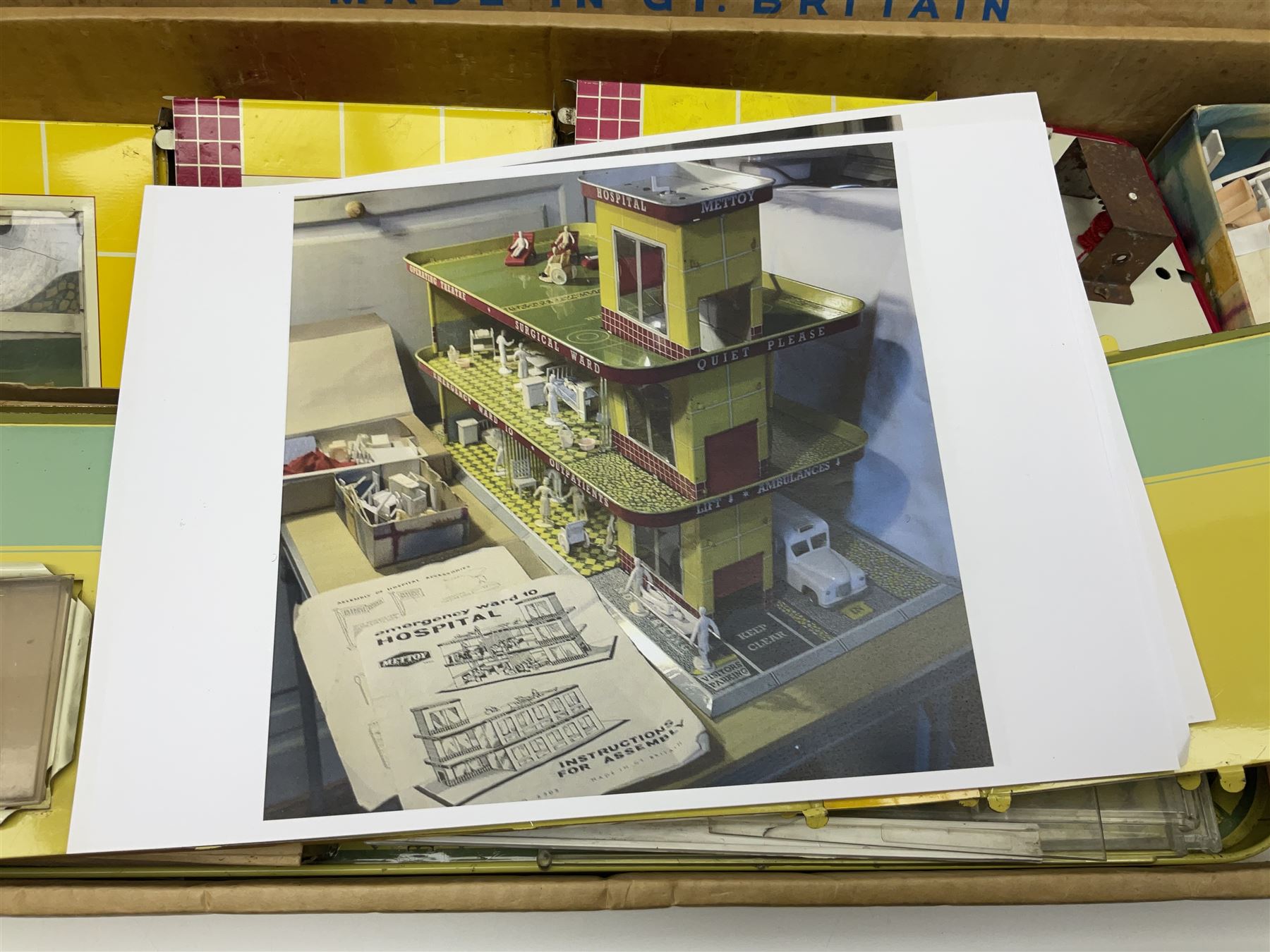 Late 1950s/early 1960s Mettoy tin-plate Emergency Ward 10 hospital set from the TV series, including over twenty figures, over sixty pieces of hospital equipment, beds, chairs, lockers, theatre fittings, stretchers etc; building is complete with movable transparent partitions, operating lift with sliding lift shaft doors and opening windows; wards with fitted swing doors; tin-plate walls with lithographed detail in yellow with red and white tiled effect, cobbled base with ambulance casualties area and lift access; boxed with instructions