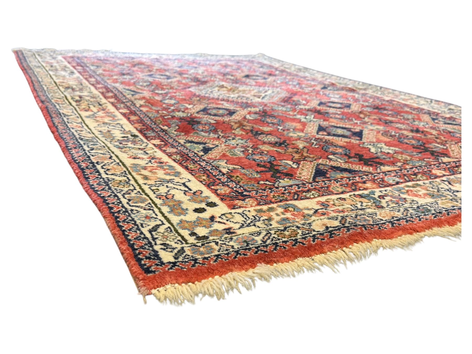 Pair of rugs one Persian hamadan rug central stepped medallion enclosing geometric motifs in ivory and brown, framed by a cream border with scrolling palmettes and fringed ends (H 156cm W 105cm), one Pakistani Bokhara rug rust red ground with repeated Tekke gul motifs within rosette and lozenged borders, fringed ends (H 98cm, W 65cm)