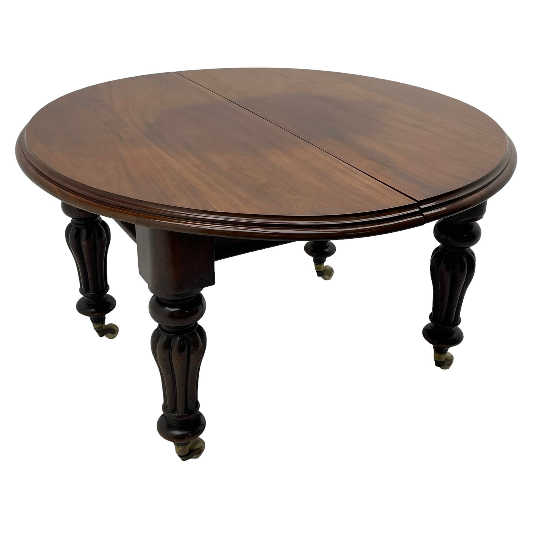 Victorian mahogany extending dining table, circular telescopic extending top with moulded edge, two additional leaves, on turned and lobe carved supports with brass and ceramic castors 