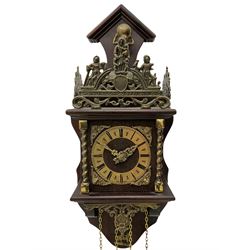 20th century Dutch style Zaanse Zaandam wall clock with a German eight-day weight driven movement housed in a wooden case on a shelf bracket with applied cast brass detail, brass effect chapter ring with Roman numerals , half-hour markers, minute track and cherub spandrels, striking the hours and half hours on a bell. With brass finished weights and pendulum.

