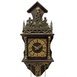 20th century Dutch style Zaanse Zaandam wall clock with a German eight-day weight driven movement housed in a wooden case on a shelf bracket with applied cast brass detail, brass effect chapter ring with Roman numerals , half-hour markers, minute track and cherub spandrels, striking the hours and half hours on a bell. With brass finished weights and pendulum.

