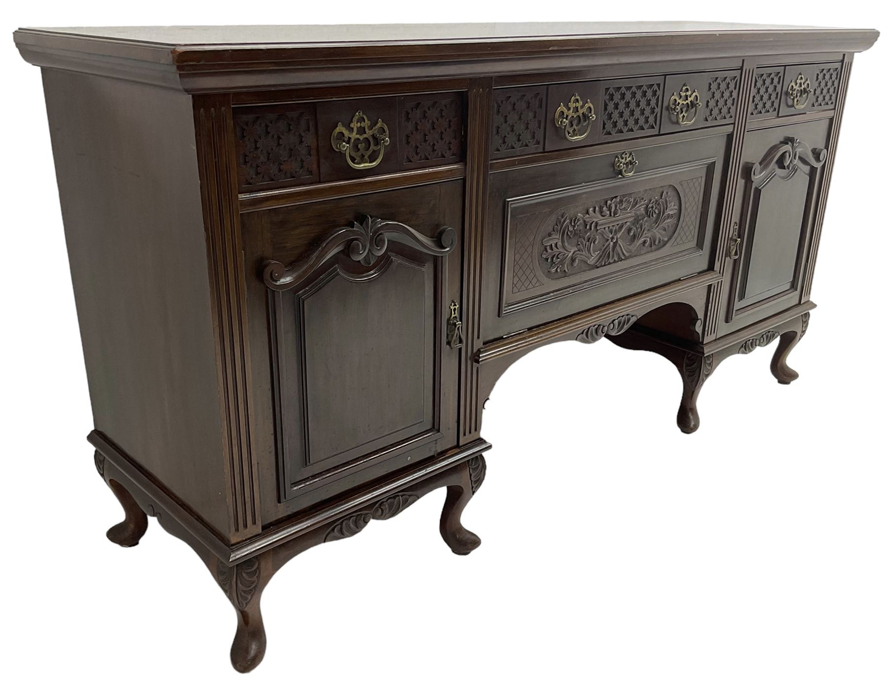 Late Victorian walnut sideboard, moulded rectangular top over three drawers  with blind fretwork facias, fitted with central fall front cupboard with extending foliage carved decoration and two flanking panelled cupboards, on acanthus carved cabriole feet