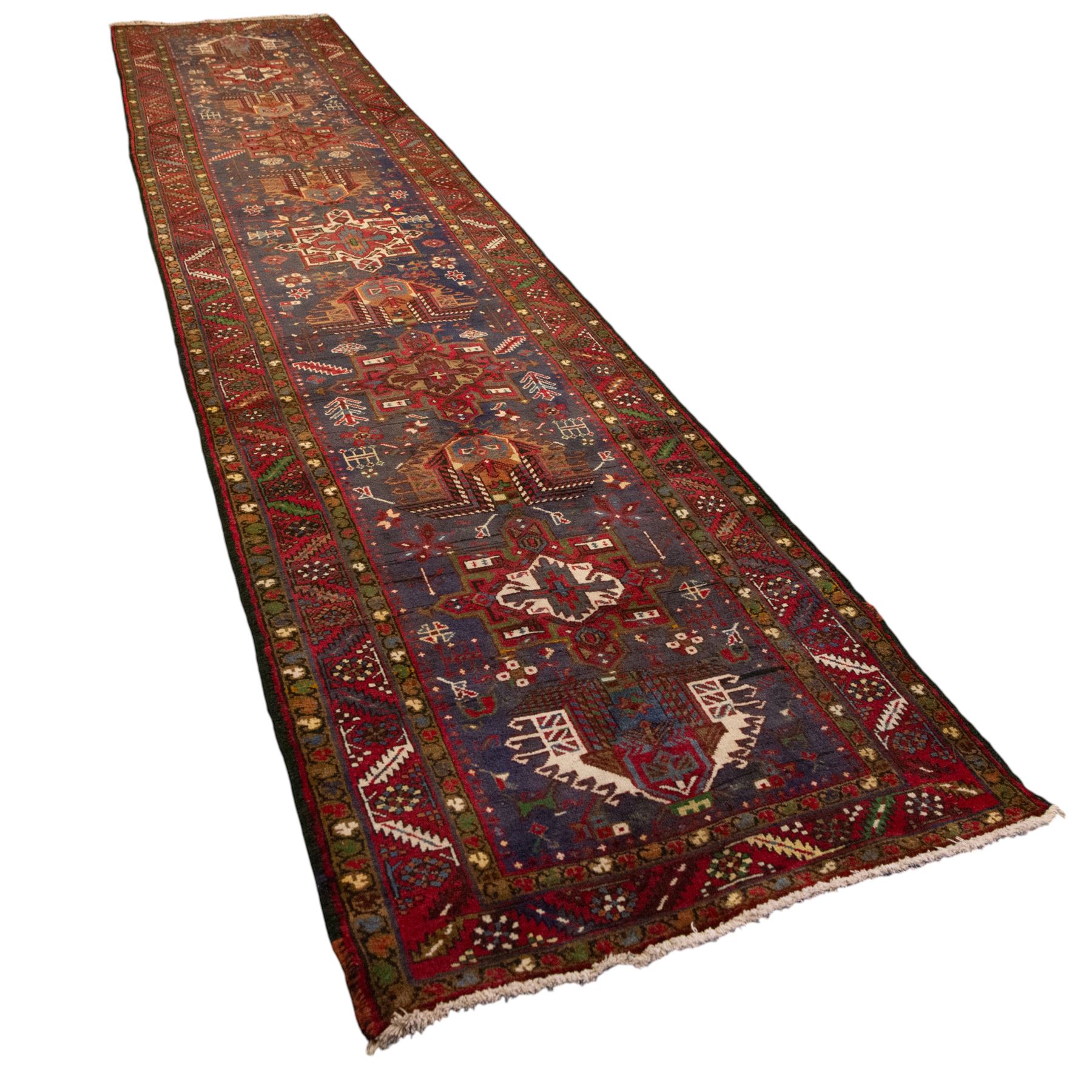 Large Northwestern Persian Hamadan hand-knotted runner, indigo field, with a column of bold geometric medallions and scattered stylized motifs within a madder border of angular rosettes and meandering vines 