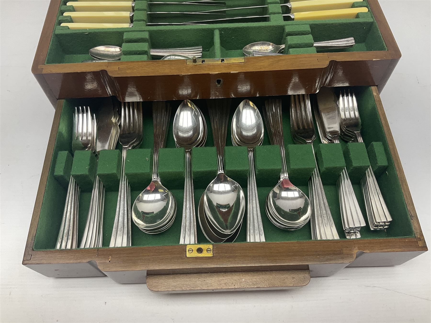 Art Deco canteen of silver plated cutlery for twelve place settings, including table and dessert knives with ivorine handles, retailed by Harrods Ltd, contained within a wooden case, with drawer to base, canteen case H15.5cm