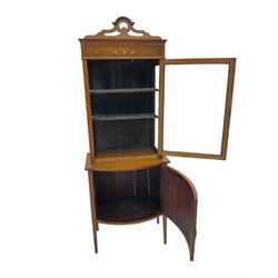 Edwardian inlaid mahogany display cabinet on cupboard, shaped pierced pediment over satinwood banded frieze inlaid with urn and scrolling foliage, enclosed by single glazed door, on bow front panelled cupboard inlaid with urn, square tapering supports