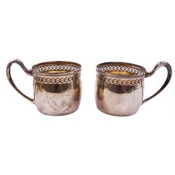 Pair of early 20th century German silver cups, each with pierced and beaded rim and curved handle, marked with crown and crescent mark, makers mark for Mosgau Franz - Berlin, and stamped 800, including handle H6.5cm, together with a set of six smaller Continental silver cups with removable white glazed ceramic inserts, the cups also stamped 800, approximate total silver weight 8.82 ozt (274.3 grams)