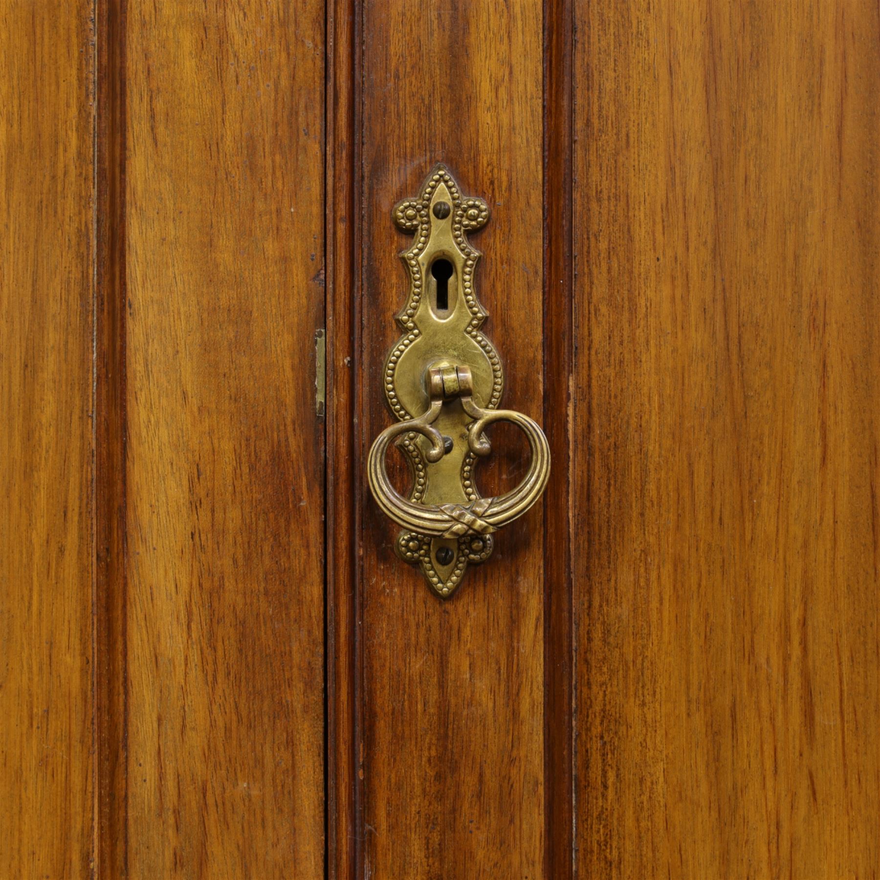 19th century mahogany triple wardrobe, moulded cornice above a central cupboard door enclosing shelves interior, flanked by full height panelled doors with clothes rails in each, the centre fitted with four graduated drawers with oval brass handles, on a moulded plinth base