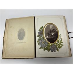  Victorian leather bound photo album, the interior leaves containing apertures of various sizes and shapes of portraits surrounded by printed floral designs, with brass clasp and painted gold decoration to edges, H30cm