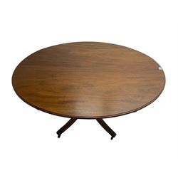George III mahogany dining table, oval tilt-top with moulded edge, raised on pedestal with quadrupod base terminating in four reeded splayed supports with brass cups and castors
