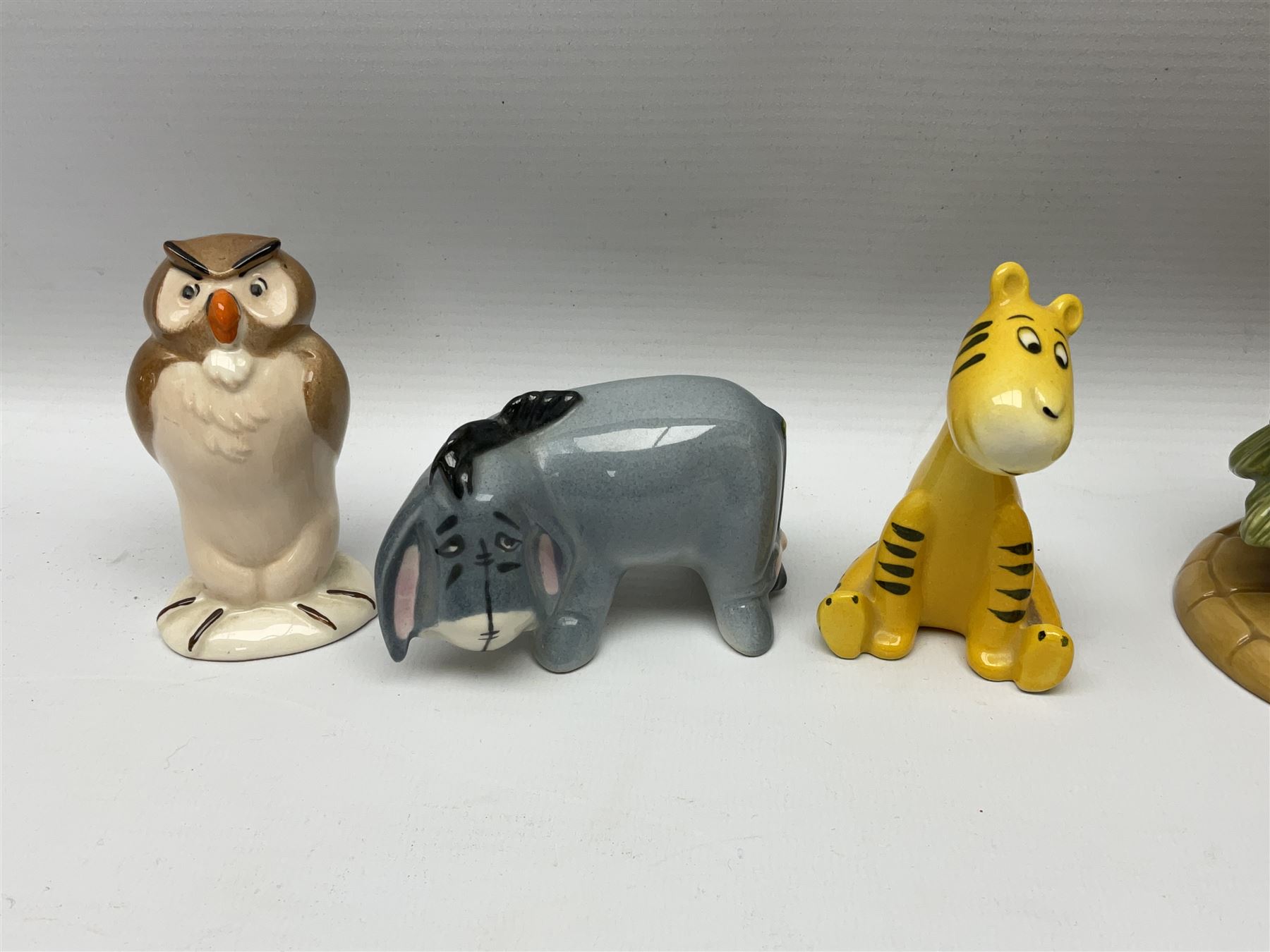 Seven Beswick Winnie the Pooh figures, comprising Pooh Bear, Tigger, Piglet, Kanga, Mr Rabbit, Owl, and Eeyore, together with two Royal Doulton Winnie the pooh Christmas Collection figures, 'The Most Perfect Tree in all the Wood', and 'Christopher Robin Dresses the Tree', (9)  