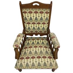 Early 20th century armchair, back and sprung seat upholstered in Art Nouveau patterned fabric, raised on ring turned supports, the frame with all-over reeded decoration