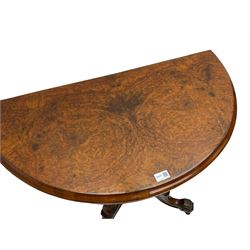 Victorian figured walnut demi-dune card table, the fold-over moulded top with circular baize lining, on four turned pillars with central finial platform, four splayed moulded supports with angular scrolled feet, on castors