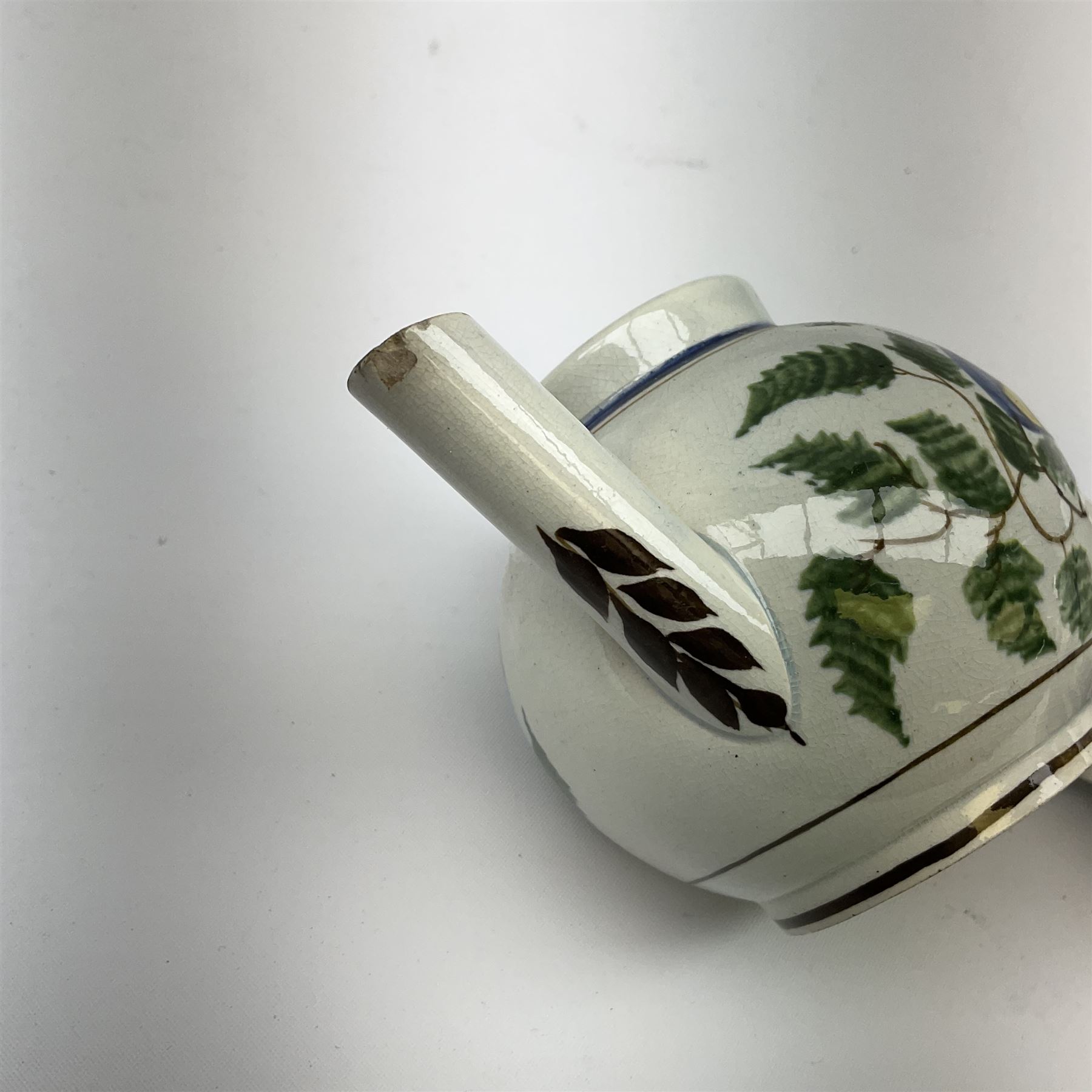 Two 18th century miniature or toy pearlware teapots, the first example lacking cover decorated with an exotic bird, the second with cover painted in underglaze blue with hut and fence, second example approximately H8cm