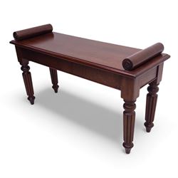 Regency style mahogany window seat, in the manner of George Bullock, with rectangular top with twin scroll ends, raised on four turned and reeded supports terminating in bun feet