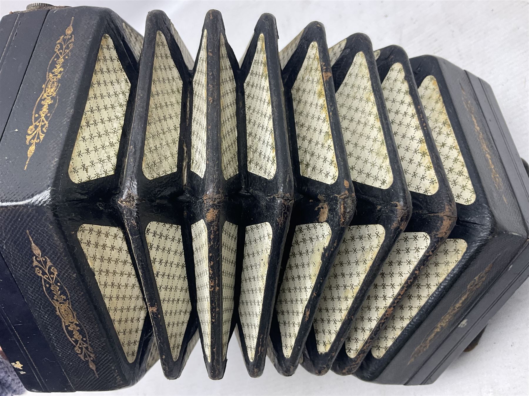 19th century Lachenal concertina of hexagonal form with fretworked nickel ends and thirty-four plus one bone buttons; straps marked Lachenal & Co Makers London and wooden handle stamped English Make Trade Mark L16cm