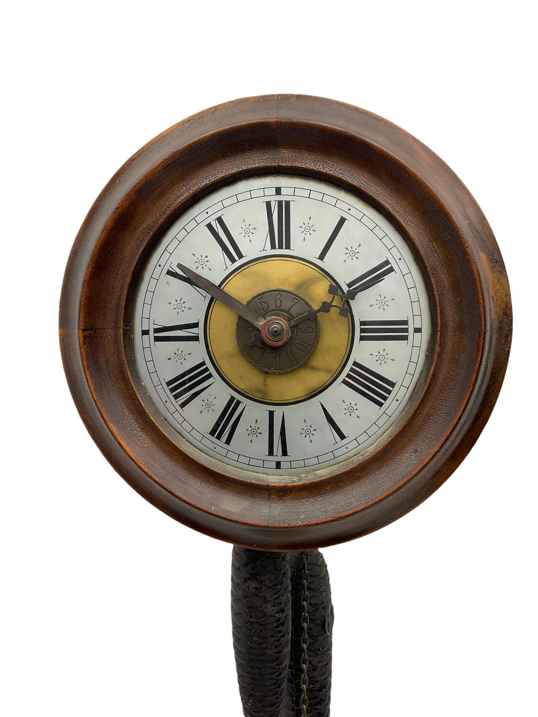 A German 30-hour chain driven wooden framed Postman’s Alarm clock, sounding on a bell, with internal wooden movement plates and brass train wheels, 7” chapter ring with roman numerals, minute track and half hour markers, with steel hands (minute hand a replacement) and alarm setting disc to the centre, with a 10-1/2” oak bezel and hinged side viewing doors. With weights and pendulum.




