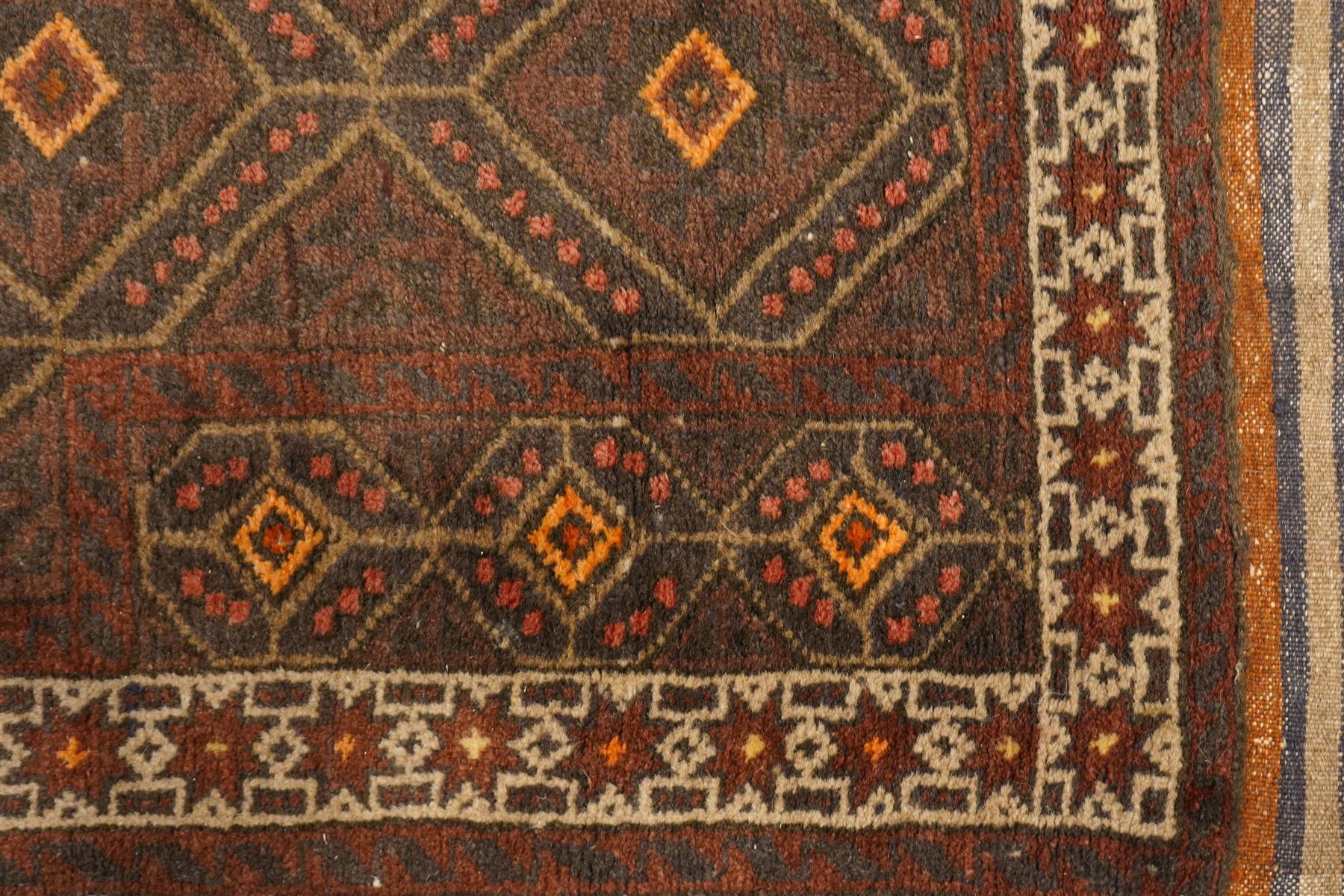 Two hand-knotted rugs, comprising Persian medallion rug and tribal rug, Persian hand-knotted rug, ivory ground centred by shaped floral medallion with pendants, surrounded by stylised flowerheads and foliate motifs, enclosed by multiple floral and geometric borders, H155cm, W123cm; tribal hand-knotted rug, dark brown ground with repeating linked geometric diamond medallions in orange and green, enclosed by ivory geometric border, striped ends with fringes, H150cm, W71cm