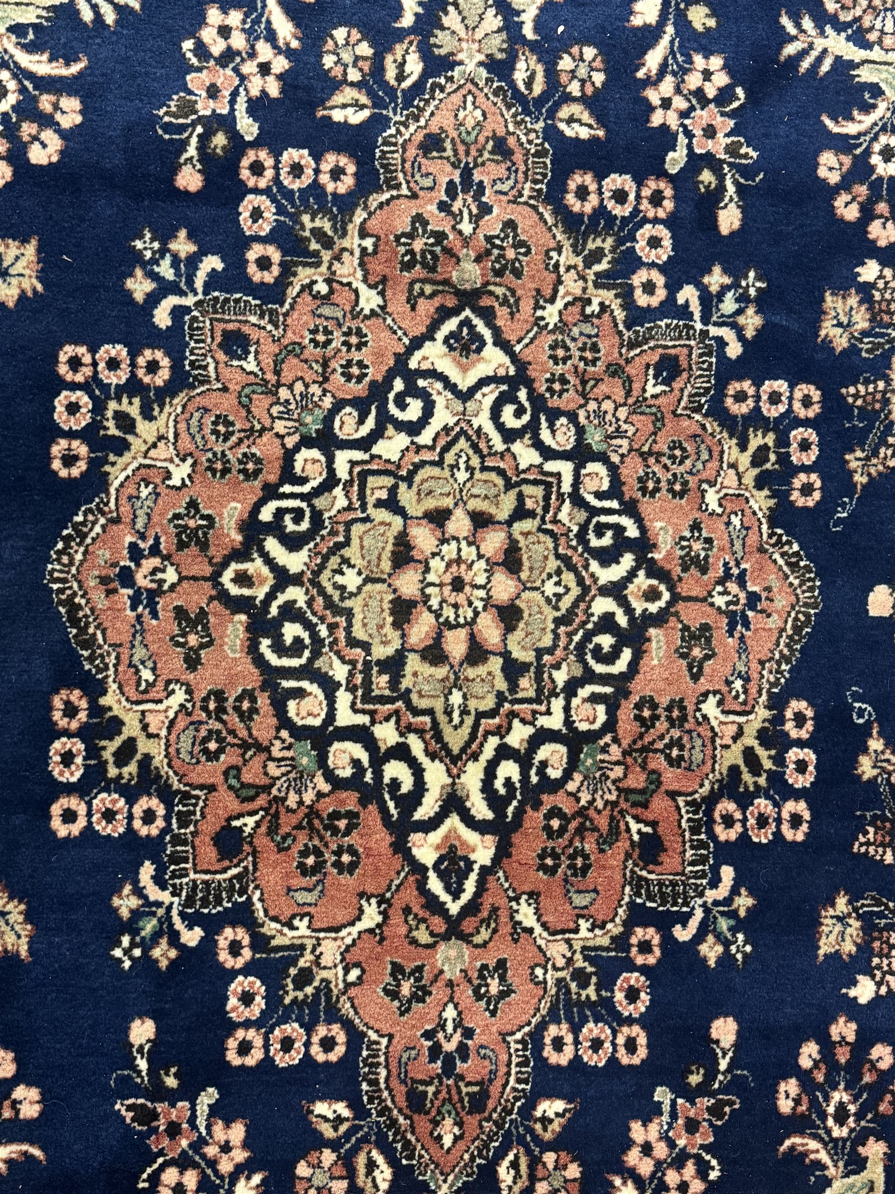 Persian Herati design indigo and red ground carpet, decorated with floral motifs, arched border