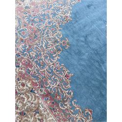 Large Persian design carpet, plain light blue field with floral design central medallion, scrolling foliate spandrels and borders decorated with flower heads