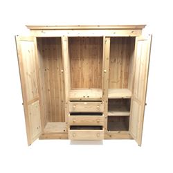 Solid pine combination wardrobe, two long doors flanking two short doors and three drawers, plinth base