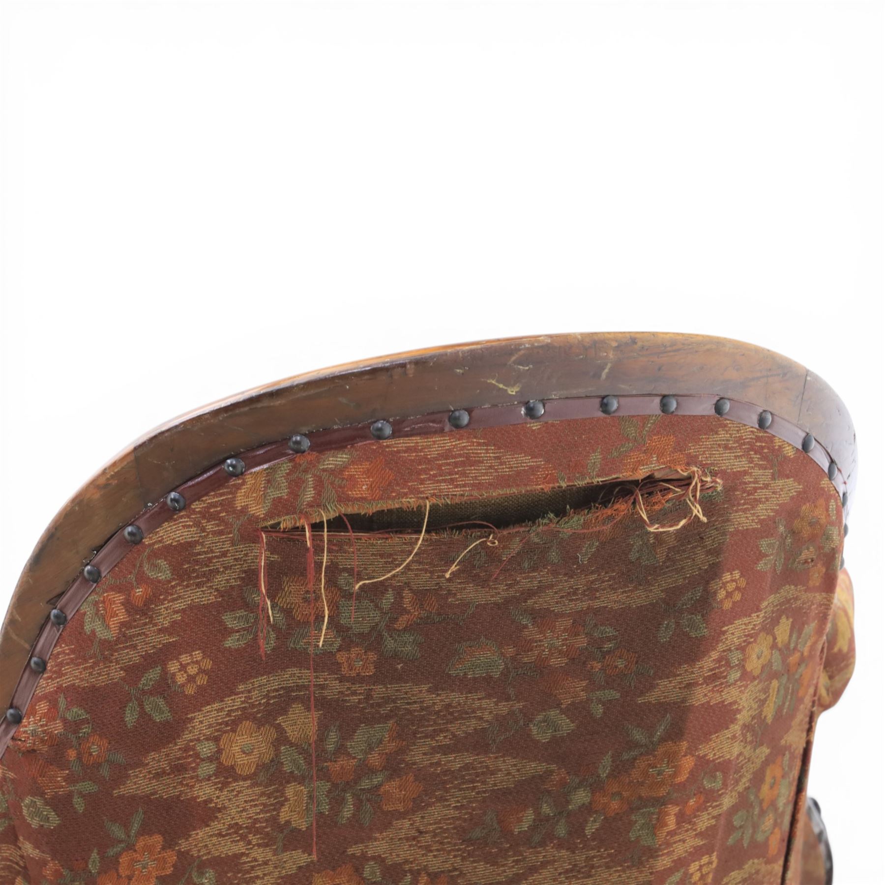 Victorian mahogany framed serpentine sofa, the shaped button upholstered back with central carved foliate cartouche, and scroll arms with carved terminals, over upholstered red seat, upon carved cabriole supports with castors