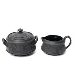 Four pieces of 19th century Wedgwood black basalt ware, c.1875, comprising larger and smaller jug, covered sucrier and teapot, each decorated with classical scenes in high relief, larger jug H13cm