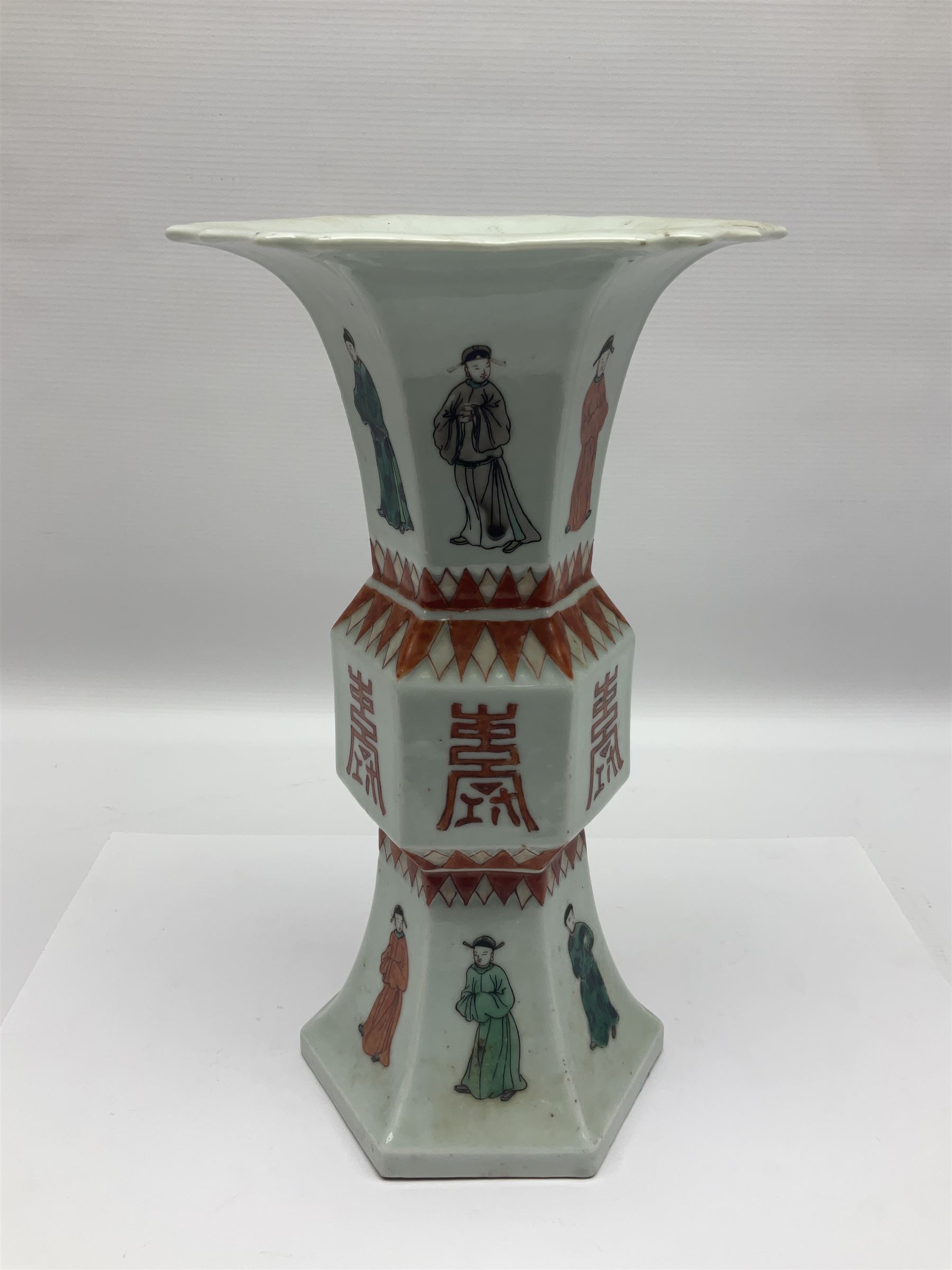 Chinese Kangxi gu vase, of hexagonal form with fluted rim, decorated in polychrome enamels with a male figure to each panel and red character marks to centre, with painted red leaf mark beneath, H32.5cm