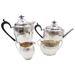 1920's silver four piece tea service, comprising teapot, hot water pot, twin handled sucrier, and milk jug, each of oval faceted form with engraved stylised border, the teapot and hot water pot with ebonised handle and finial, hallmarked Roberts & Belk Ltd, Sheffield 1925, approximate gross weight 46.13 ozt (1434.8 grams)