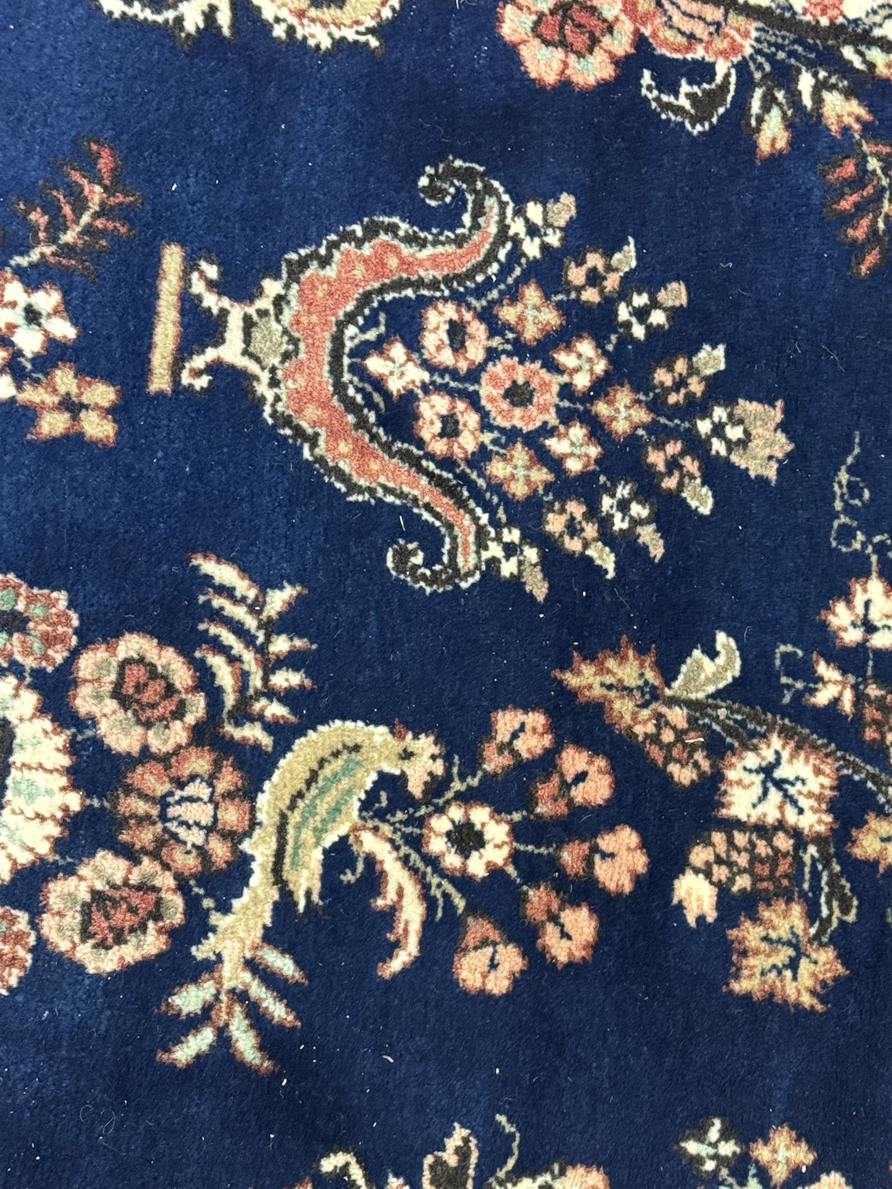 Persian Herati design indigo and red ground carpet, decorated with floral motifs, arched border