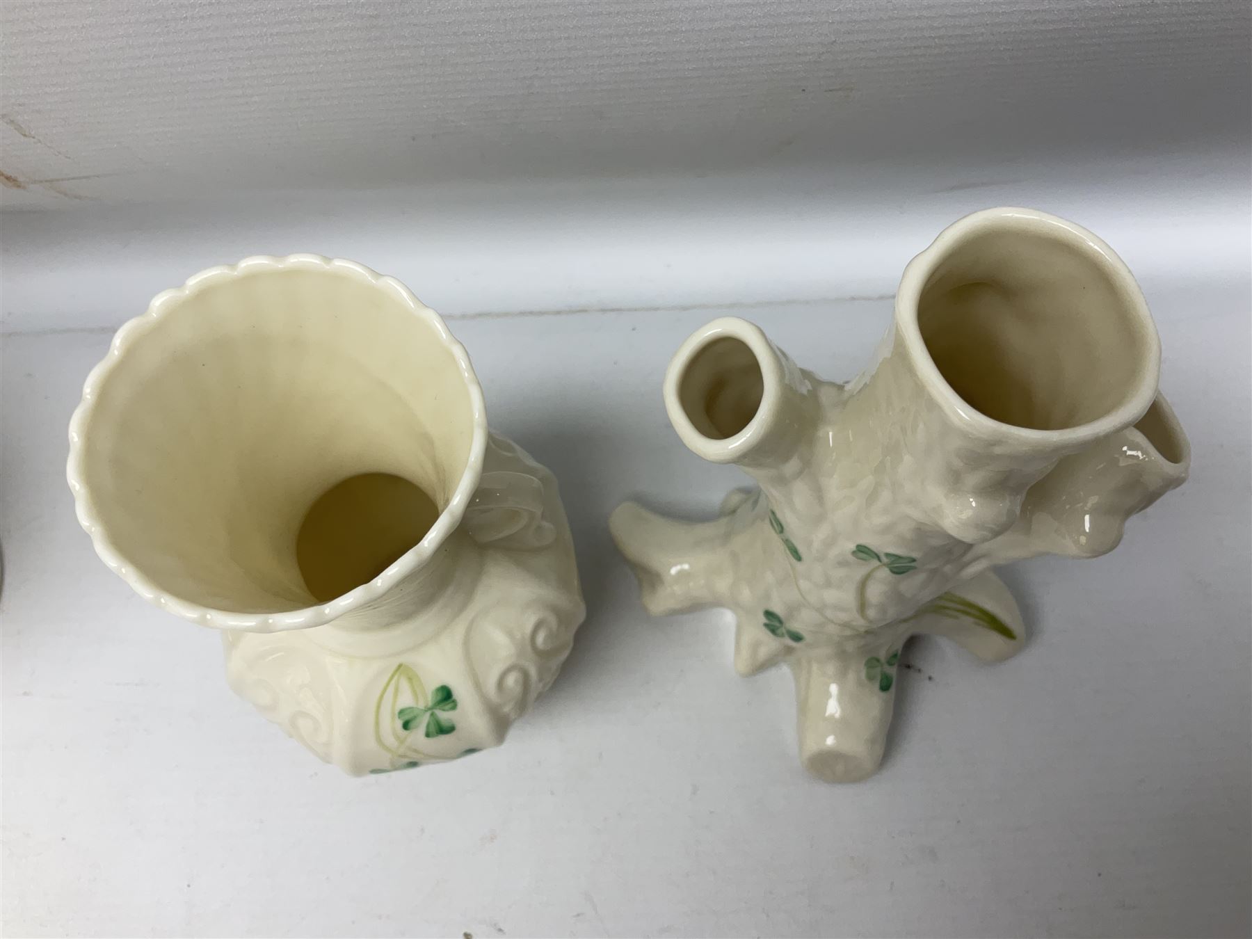 Five late 19th/early 20th century and later Belleek vases, comprising pair of Lotus Blossom examples, shamrock tree trunk vase, twin handled shamrock vase and a baluster form vase decorated with applied roses, all with printed marks beneath, tallest H16cm