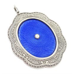 Early 20th century silver guilloche enamel portrait pendant, set with an oval miniature of a gentleman wearing a grey suit on ivory, within a blue enamel and marcasite border, the reverse set with a blue enamel panel and single split pearl, within a silver engraved border, suspended from a marcasite bail

This lot has been registered for sale under Section 10 of the APHA Ivory Act