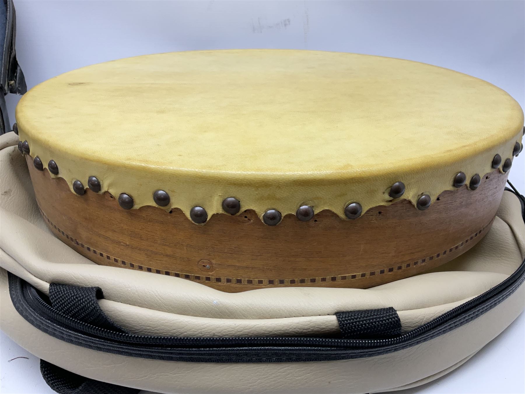 Dulcet eight-string banjo mandolin with mother-of-pearl inlaid ebonised fingerboard L55.5cm; cased; and Irish mahogany bodhran hand drum with inlaid stringing and vellum top D46.5cm; in soft carrying case with double ended beater (2)