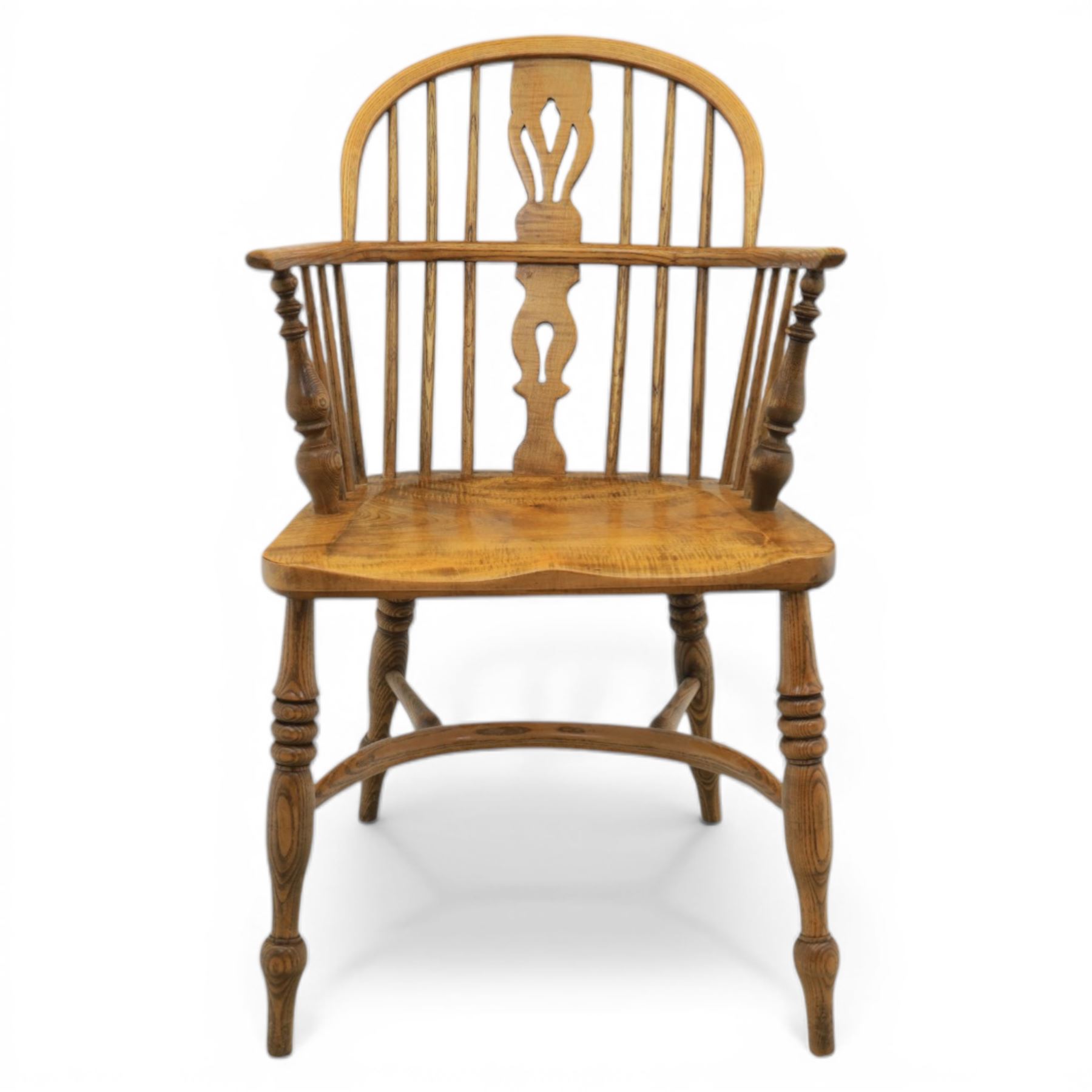 Late 20th century elm and beech low back country Windsor armchair, the arched hoop back with central pierced splat and turned spindles, shaped arm rail on turned supports, saddle seat, raised on turned legs united by a crinoline stretcher
