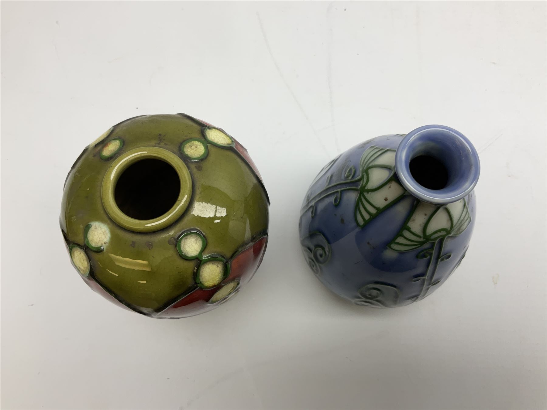 Minton Secessionist vase, with tube-lined stylised flower head decoration on a blue ground, printed mark to base 'Minton Ltd, No. 30', together with another Minton Secessionist tubelined vase,  printed mark to base 'Minton Ltd, No. 16', tallest example H13.5cm