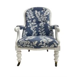 Victorian white painted open armchair, upholstered in blue fabric decorated with trailing leaf pattern, scrolled arm terminals on turned front supports with castors