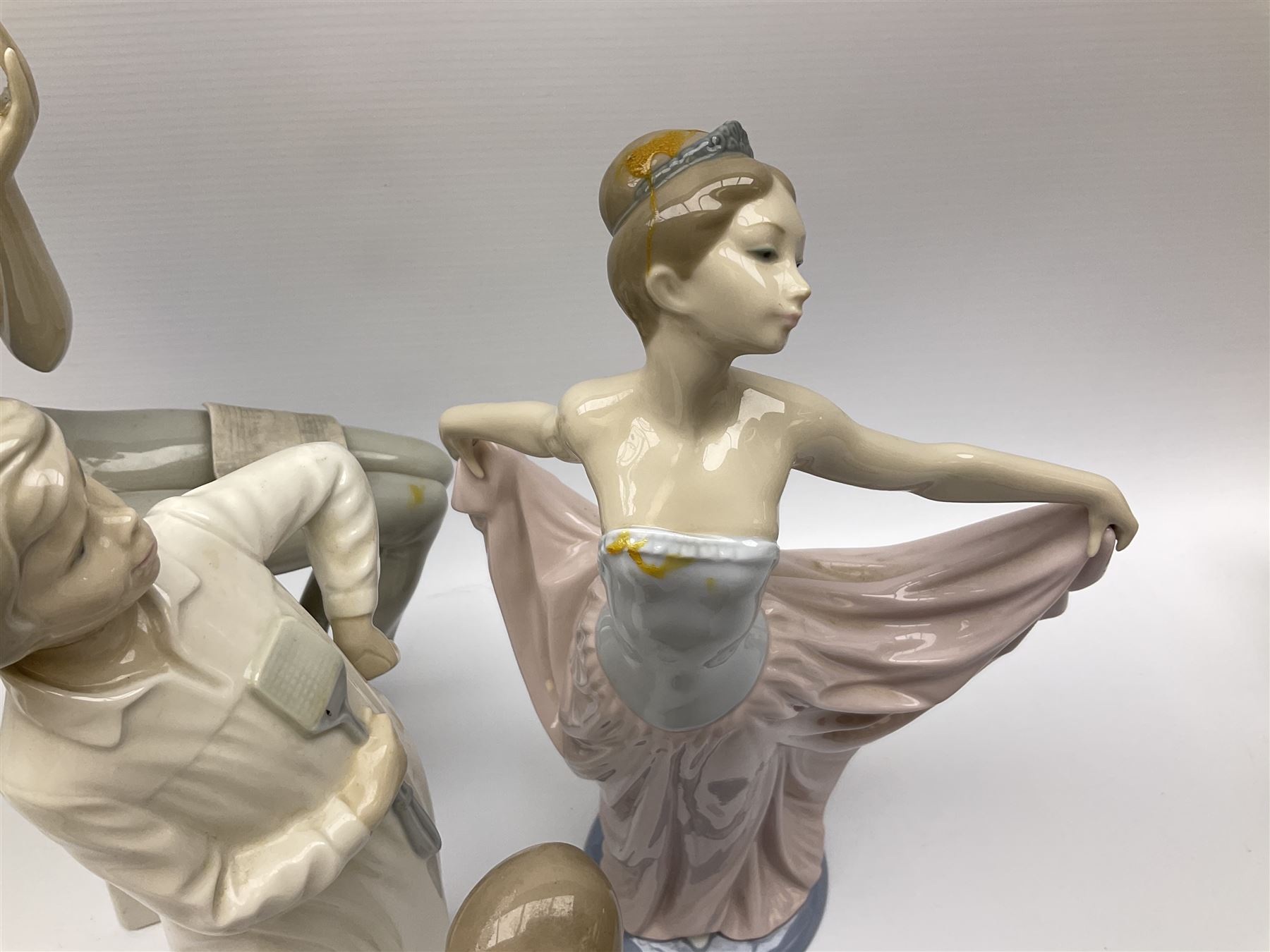 Collection of seven Lladro figures, including Seated ballerina with swan 6204, Childhood Dream 8129, Dancer 5050, reclining clown with ball alongside a selection of other figures. 