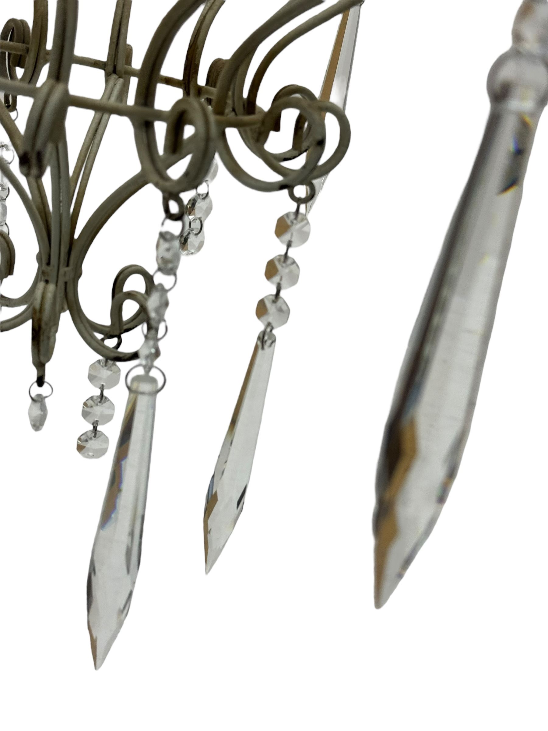 India Jane Interiors - six branch metal chandelier, the scrolled crown over circular bulbous body with six projecting branches, decorated with scroll work and glass pendants, in distressed white paint finish - ex-display/bankruptcy stock 