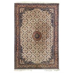 Indo-Persian Herati design ivory ground rug, central medallion on a field of repeating floral Herati motifs, peach ground border with repeating pattern, enclosed by guard stripes 