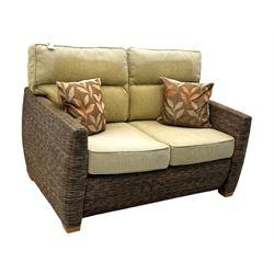 Contemporary two seat rattan conservatory sofa with loose cushions, and pair of matching armchairs, with upholstered seat and back cushions in a beige fabric, curved arms and front complete with scatter cushions 

Chairs (H 92cm, W 75cm, D 84cm)
Sofa (H 92cm, W 130cm, D 84cm)