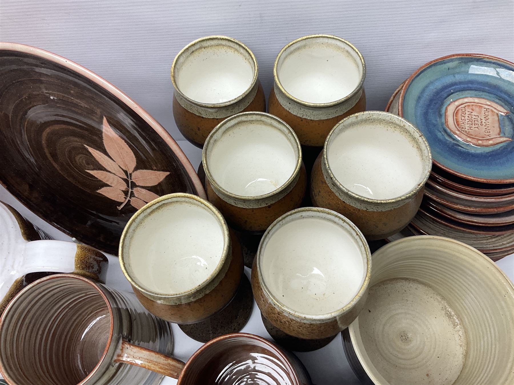 Wold studio pottery tankards, in various colours and relief decoration together with other studio items including vases, jugs and pots 