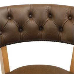 Captain's swivel desk chair upholstered in buttoned tan leather, button backed chair rail, padded and downswept arms, raised on a six point base with castors