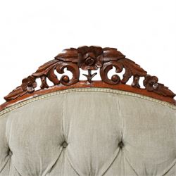 Victorian walnut double-ended settee, shaped cresting rail with foliate carved pediment, upholstered in buttoned sage green fabric, on cabriole feet