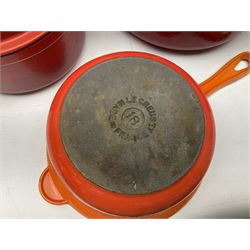 Quantity of Le Creuset cast iron kitchenaelia comprising yellow oval lidded casserole dish, size 29, Volcanic Orange sauce pan, size 18, and blue lidded casserole dish, size 27, together with set of three graduating Invicta red lidded twin handled lidded dishes