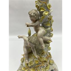 Dresden style candelabra, the central stem bordered by three branches, decorated with cherubs and yellow roses, H48cm