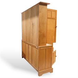 Yorkshire oak dresser, projecting top over open centre fitted with shelf, small double cupboard and flanking full height cupboards, the lower section fitted with three drawers and cupboards, enclosed by panelled doors, on plinth base
